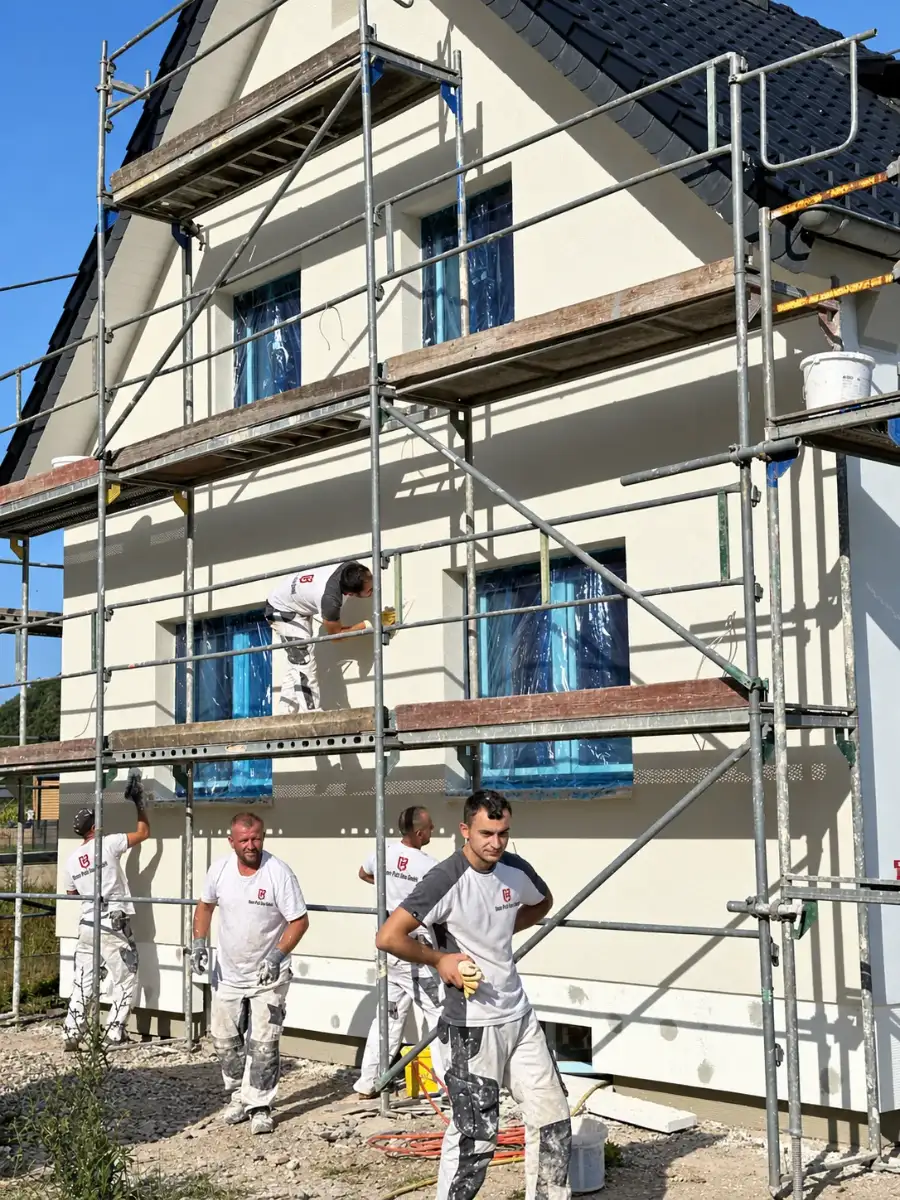 Team von Bonn Putz Bau verputzt die Fassade eines Einfamilienhauses am Gerüst