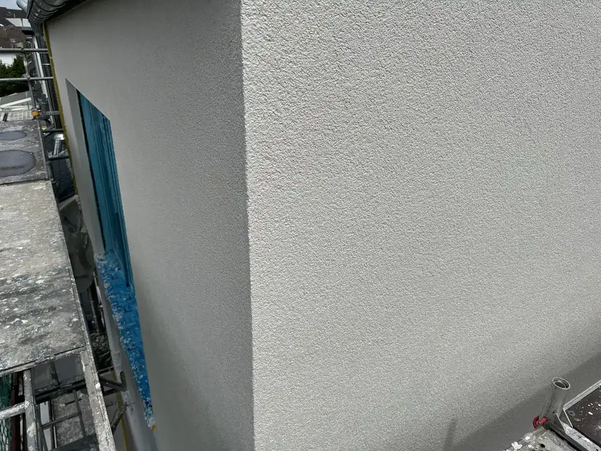 Hausecke mit frischem hellem Oberputz am Gerüst