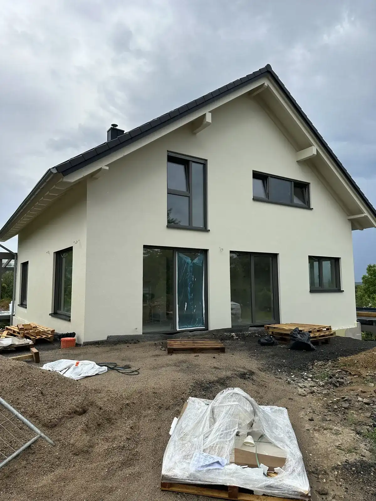 Neubau-Einfamilienhaus mit frisch verputzter heller Fassade