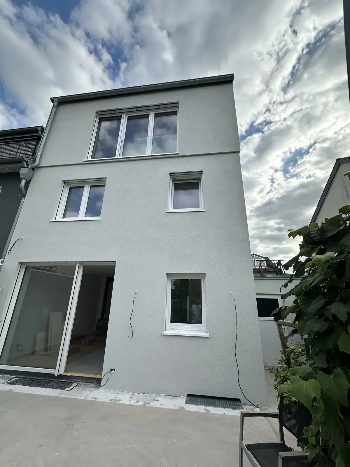 Rückfassade eines Reihenhauses mit neuem hellgrauem Putz