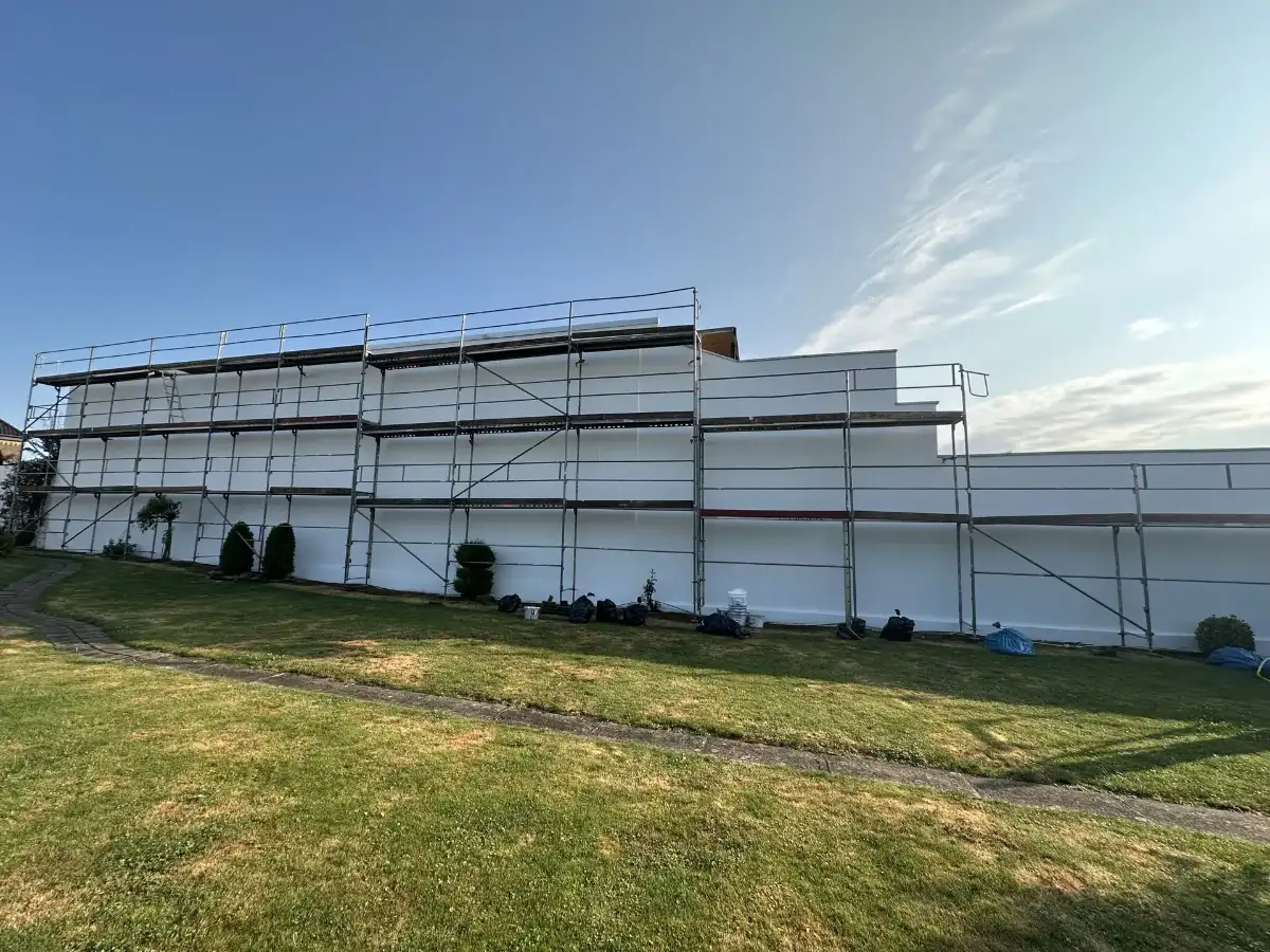 Dieselbe Fassade nach der Sanierung, frisch weiß verputzt
