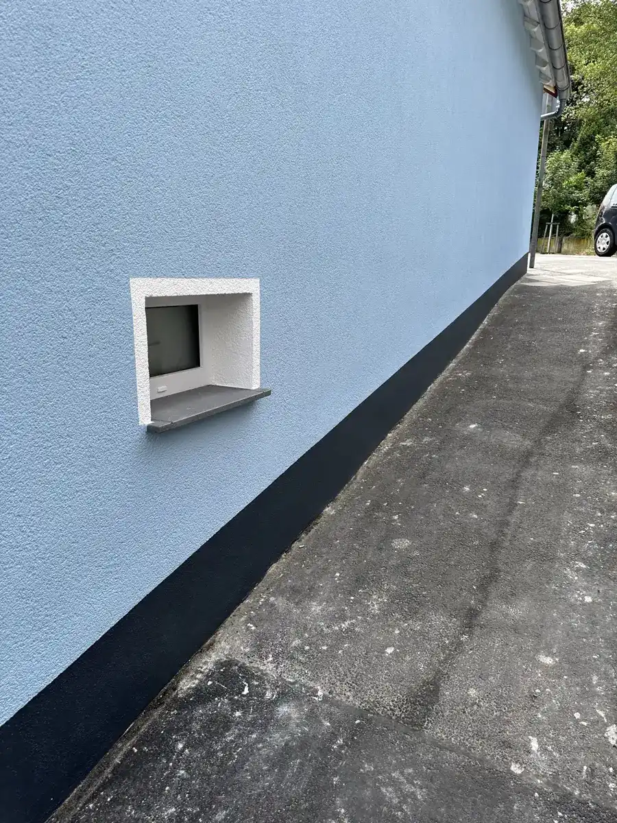 Fassadensockel mit Kellerfenster nach der Abdichtung