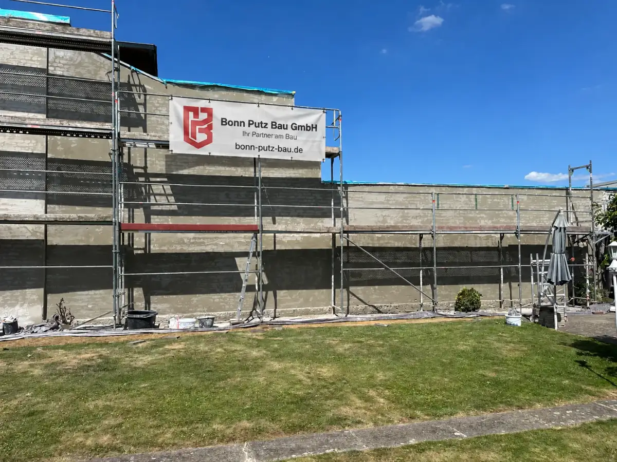 Lange Hauswand mit neuem Unterputz, eingerüstet, mit Banner von Bonn Putz Bau