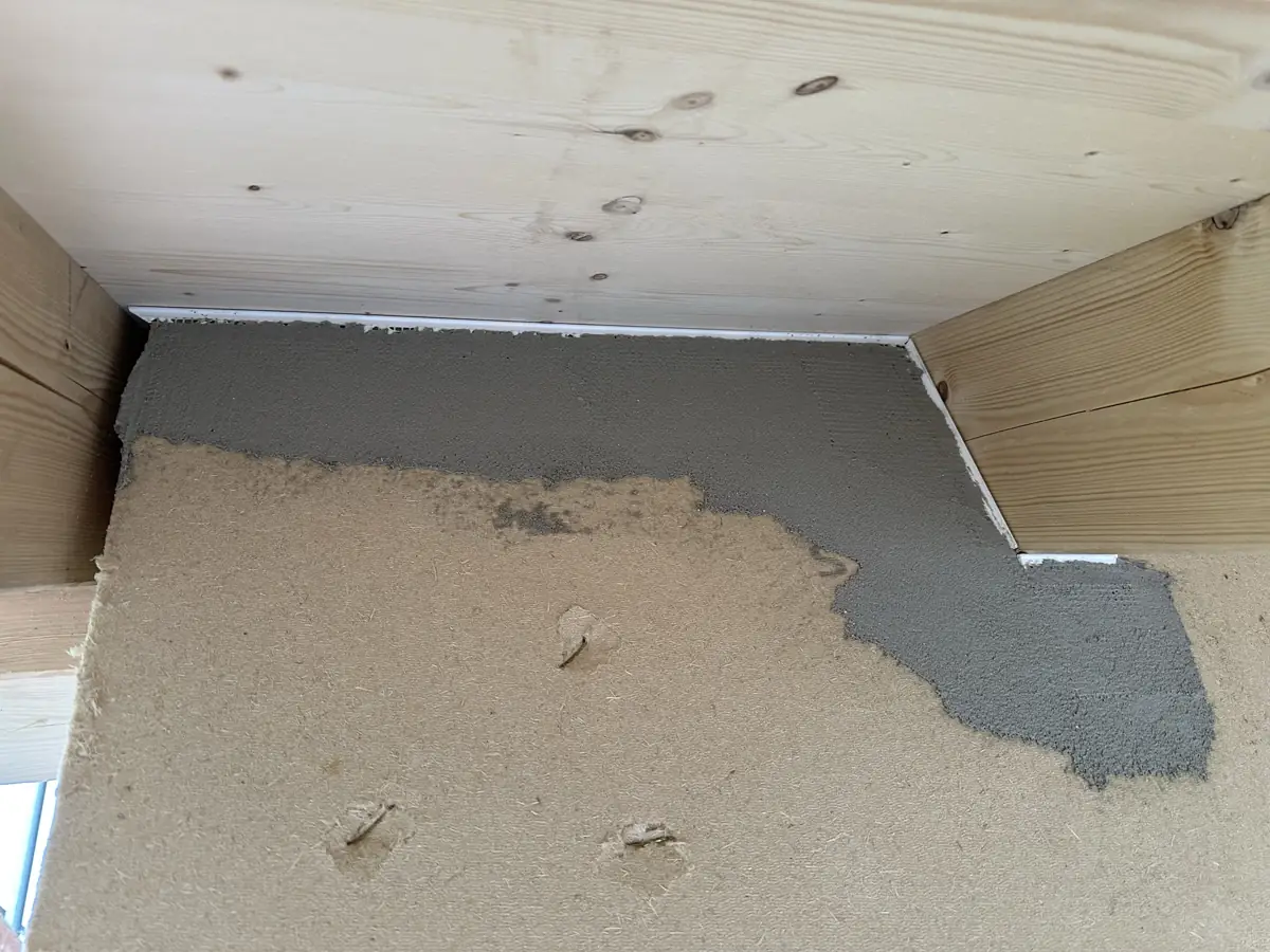 Holzfaserdämmplatte mit beginnender grauer Armierungsschicht unter dem Dachüberstand