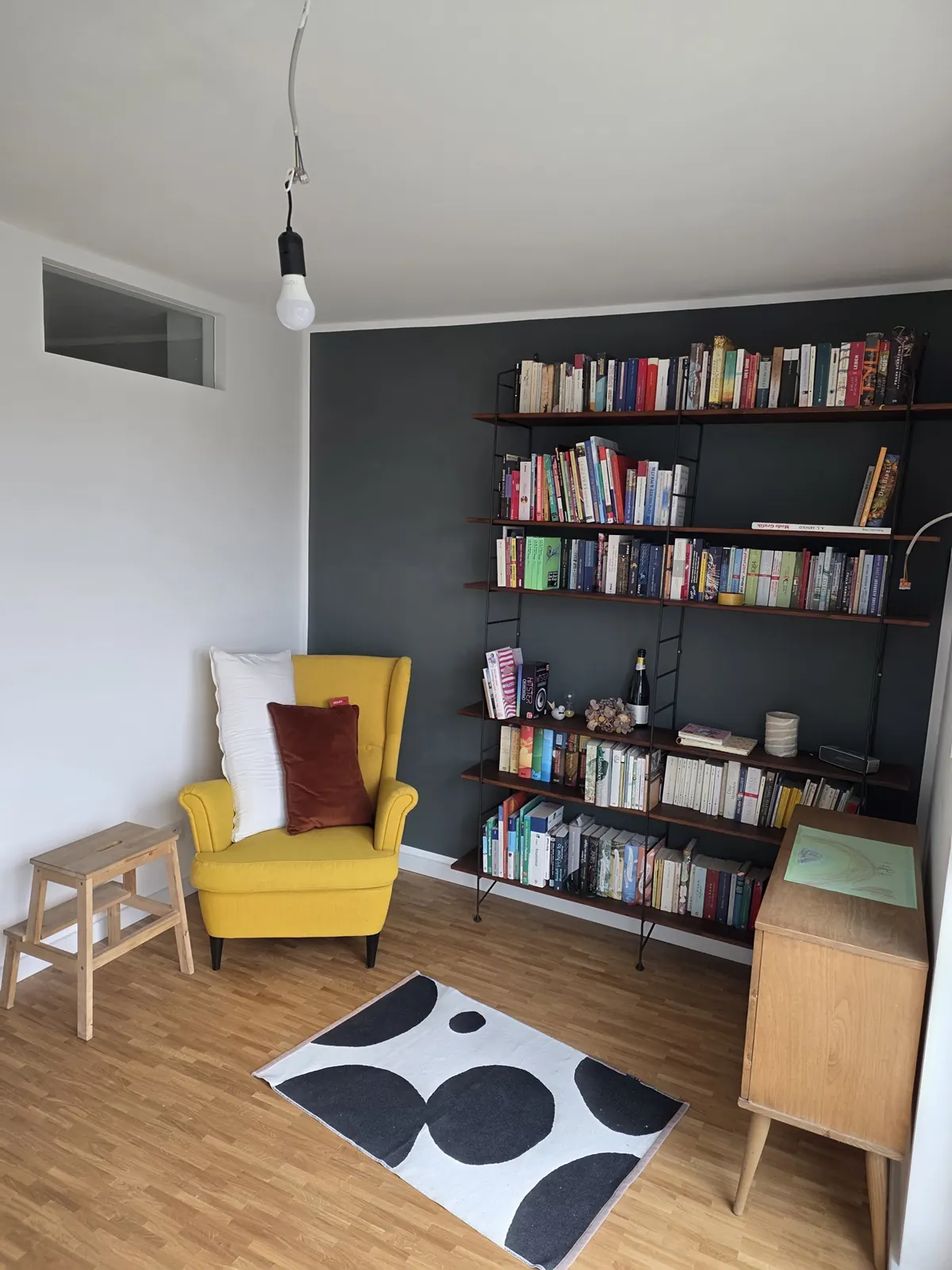 Leseecke mit dunkel gestrichener Wand nach dem Innenausbau