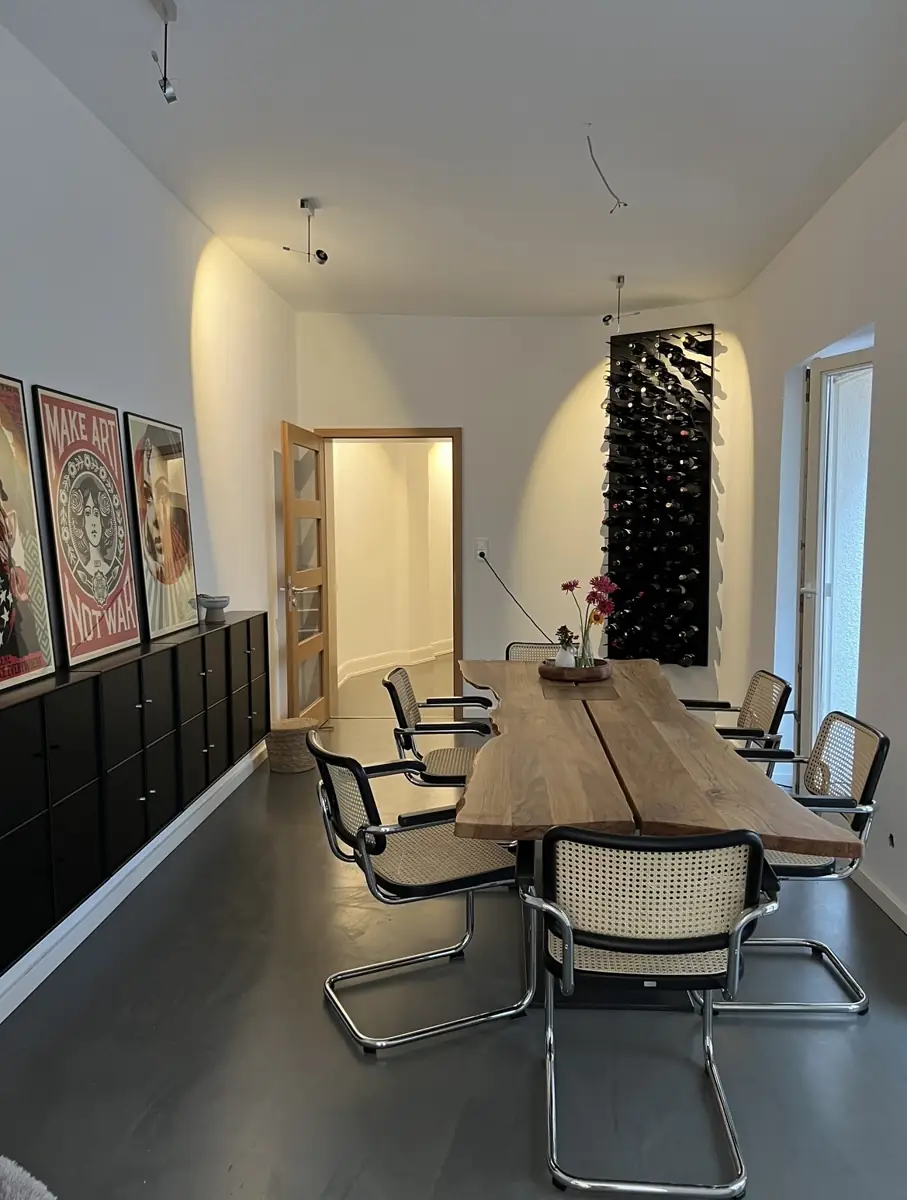 Renoviertes Esszimmer im Altbau mit Holztisch und Weinregal