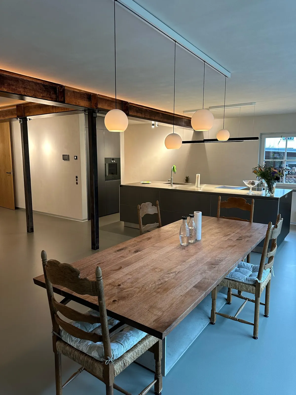 Renovierter Essbereich im Loft mit Holzbalken und Pendelleuchten