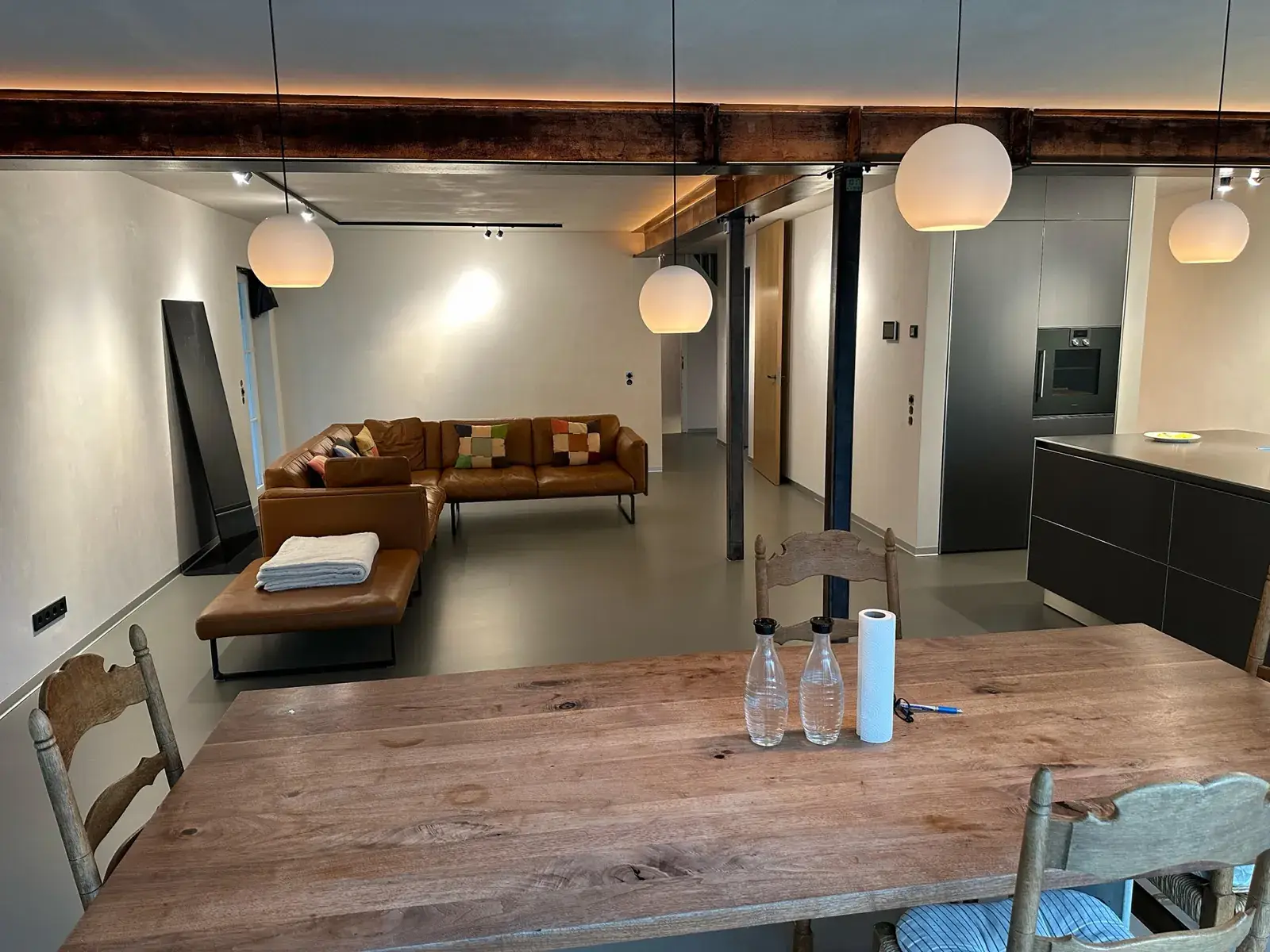 Loft-Wohnraum mit Stahlträgern, Holzbalken und hellen Wänden
