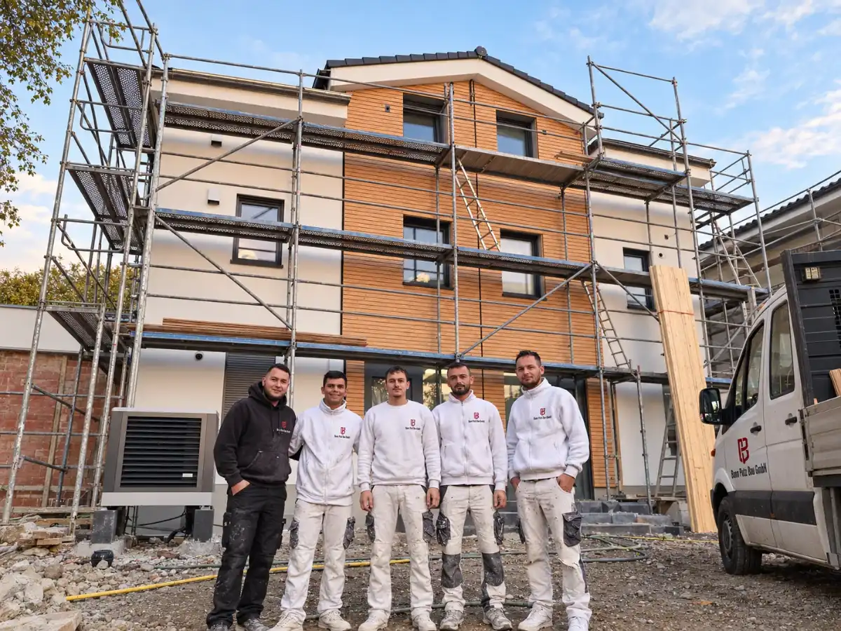 Team von Bonn Putz Bau mit Firmenwagen vor einem eingerüsteten Neubau