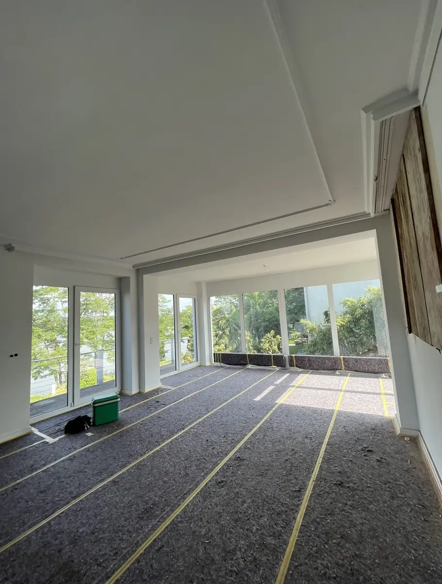 Gipskartondecke mit Lichtvoute in einem Raum mit großer Fensterfront