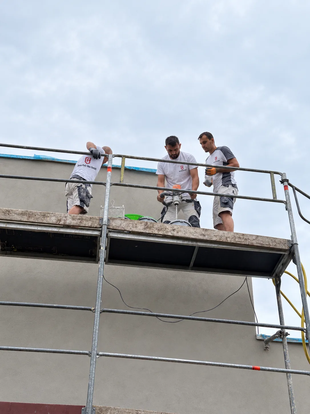 Verputzer von Bonn Putz Bau arbeiten auf dem Gerüst an einer Hausfassade