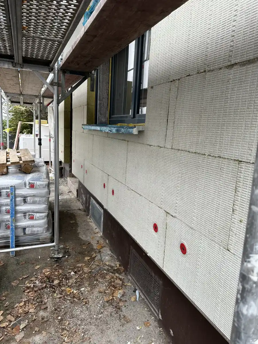 Gedübelte Dämmplatten an einer Fassade unter dem Gerüst