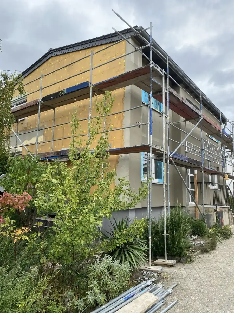 Mehrfamilienhaus mit Dämmplatten an der Fassade, eingerüstet