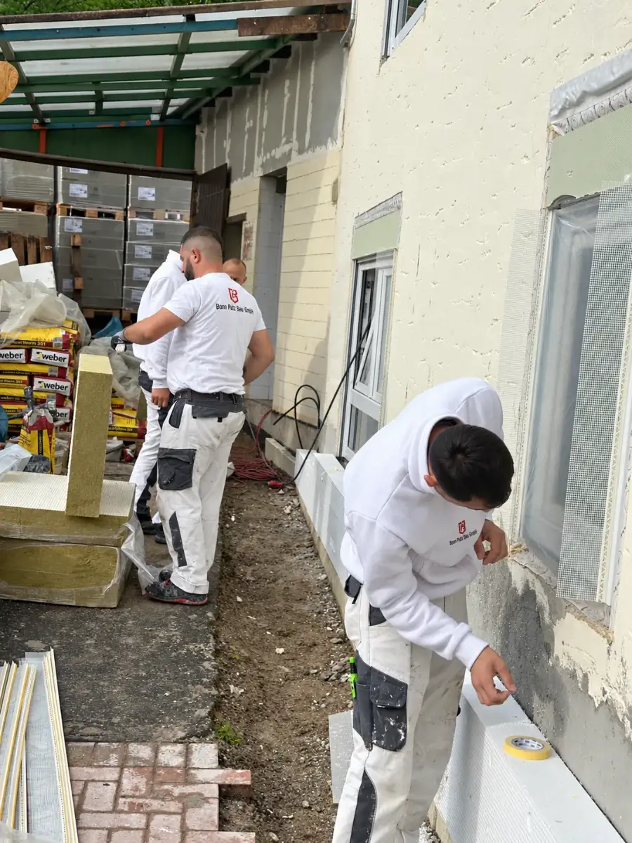 Mitarbeiter von Bonn Putz Bau bei der Fassadendämmung mit Mineralwolle-Platten